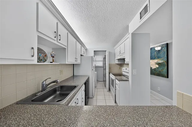 a kitchen with stainless steel appliances granite countertop a refrigerator and a sink