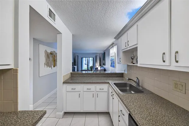 a kitchen with granite countertop a sink a stove and cabinets