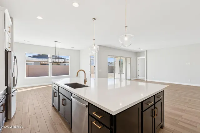 a kitchen with a sink a counter space and wooden floor