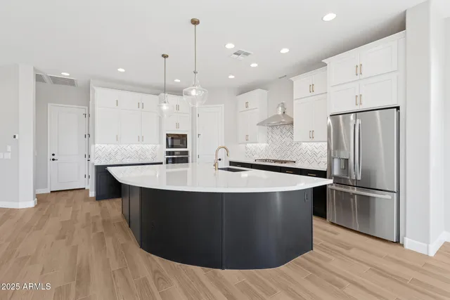 a kitchen with kitchen island stainless steel appliances a sink and a refrigerator