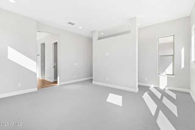 a view of empty room with wooden floor and window