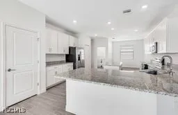 a kitchen with stainless steel appliances granite countertop a sink refrigerator and cabinets