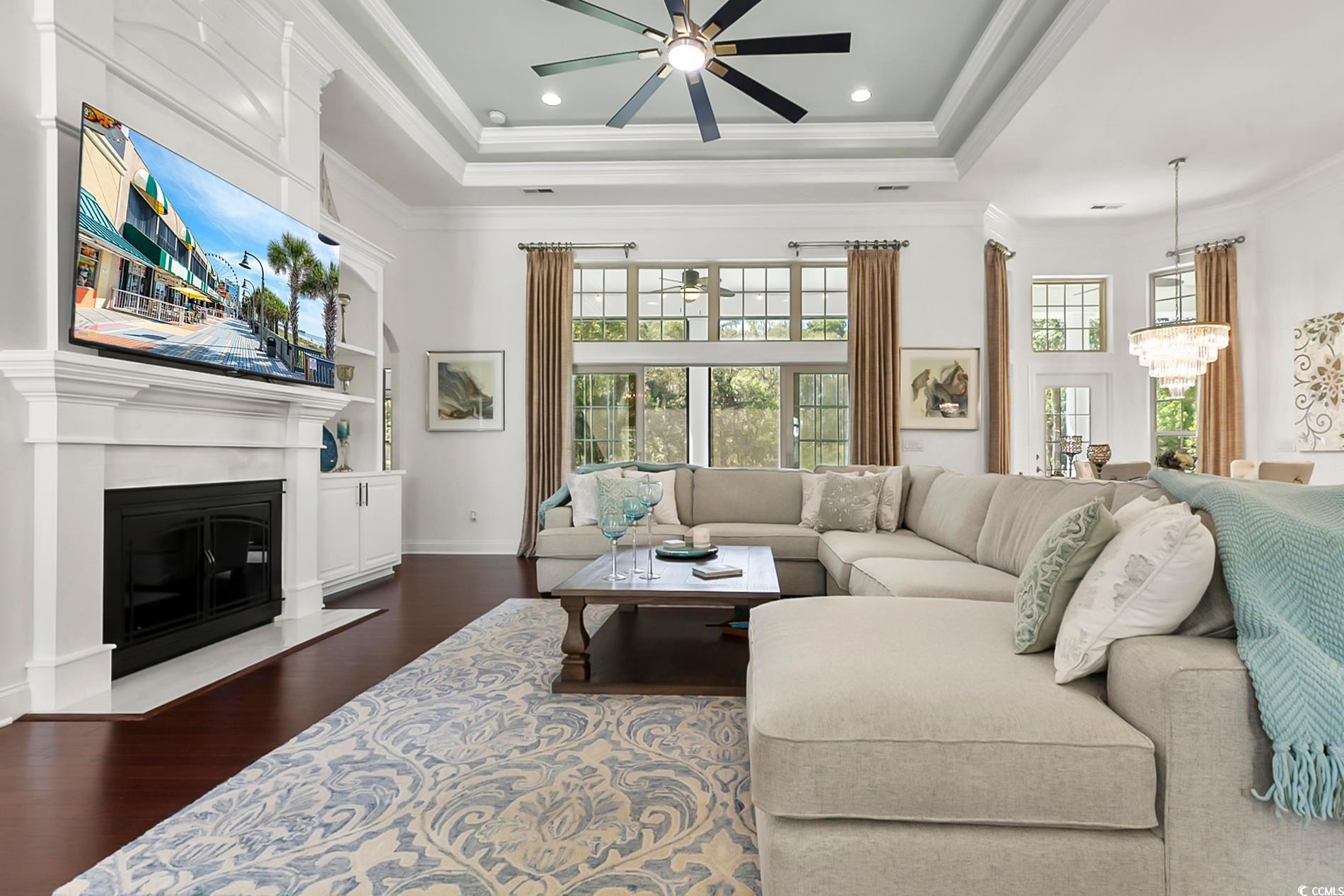 4000 Girvan Drive Myrtle Beach, SC 29579 - Photo 11 of 40 Living room featuring ornamental molding, a fireplace with flush hearth, dark wood-style floors, a raised ceiling, and recessed lighting