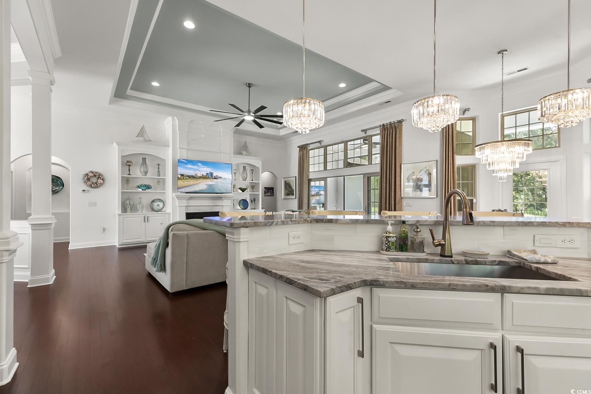 4000 Girvan Drive Myrtle Beach, SC 29579 - Photo 18 of 40 Kitchen with a tray ceiling, light stone counters, decorative columns, white cabinets, and dark wood-style floors