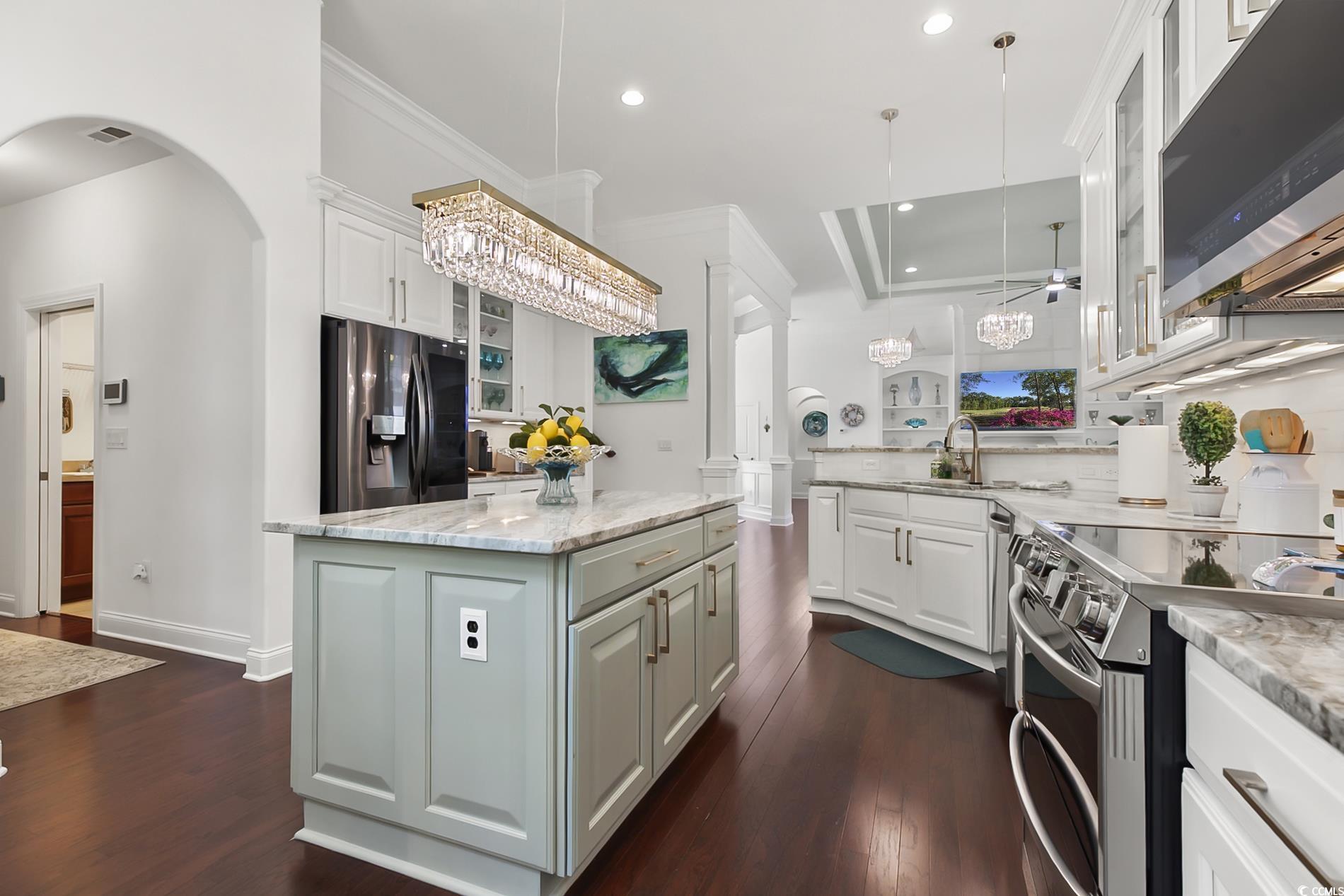 4000 Girvan Drive Myrtle Beach, SC 29579 - Photo 19 of 40 Kitchen featuring glass insert cabinets, appliances with stainless steel finishes, ornamental molding, dark wood-type flooring, and light stone counters