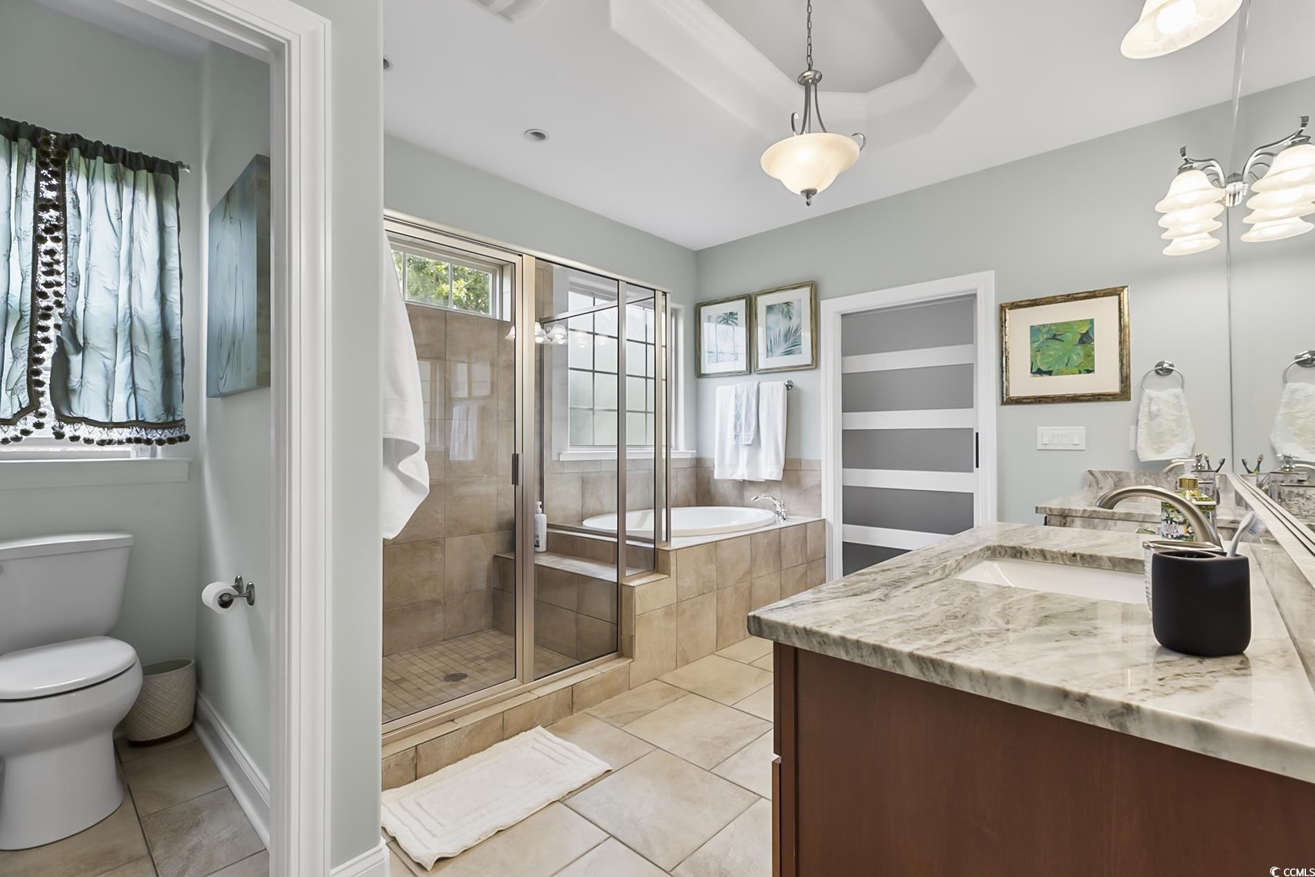 4000 Girvan Drive Myrtle Beach, SC 29579 - Photo 26 of 40 Full bathroom featuring double vanity, a shower stall, light tile patterned floors, and a bath