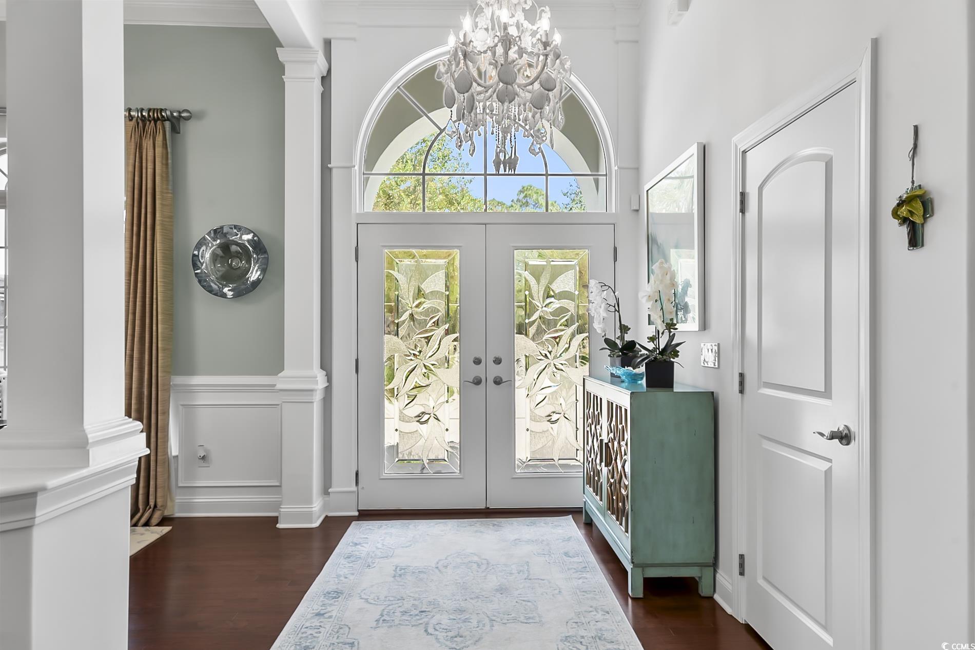 4000 Girvan Drive Myrtle Beach, SC 29579 - Photo 6 of 40 Doorway to outside featuring a decorative wall, wood finished floors, a chandelier, french doors, and wainscoting