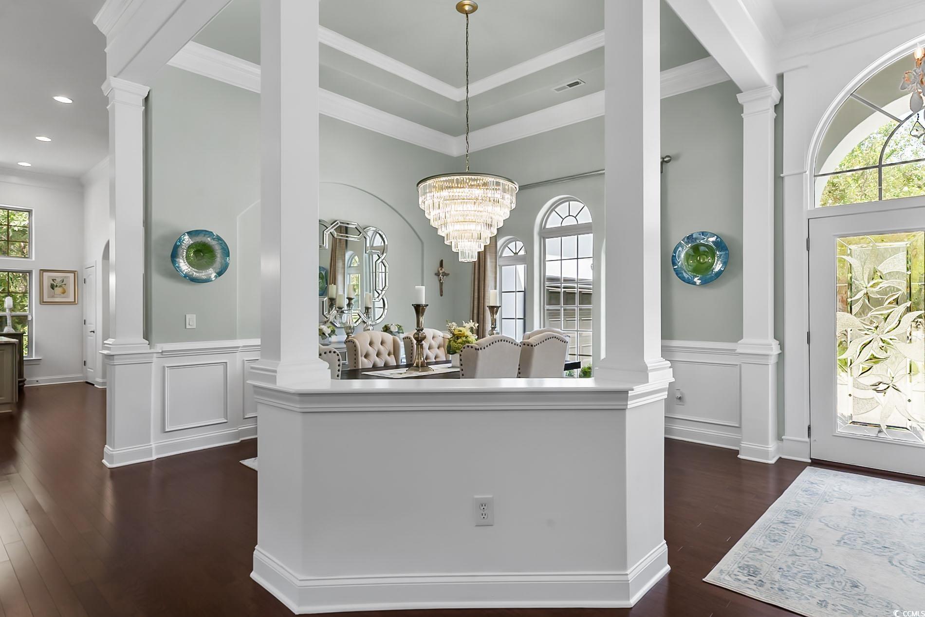 4000 Girvan Drive Myrtle Beach, SC 29579 - Photo 9 of 40 Entryway featuring ornate columns, dark wood finished floors, plenty of natural light, a chandelier, and crown molding