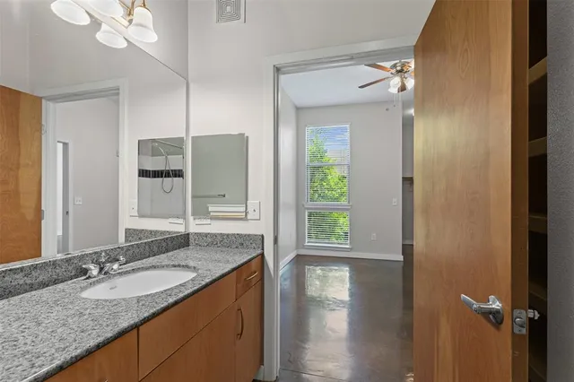 a bathroom with a granite countertop sink and a mirror