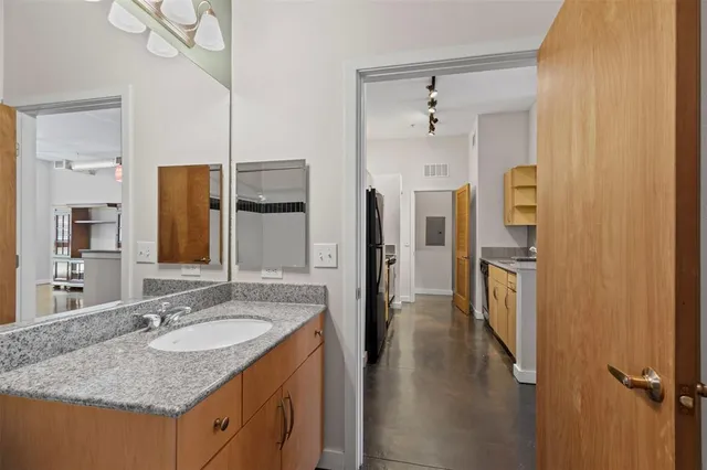 a bathroom with a granite countertop sink and a mirror