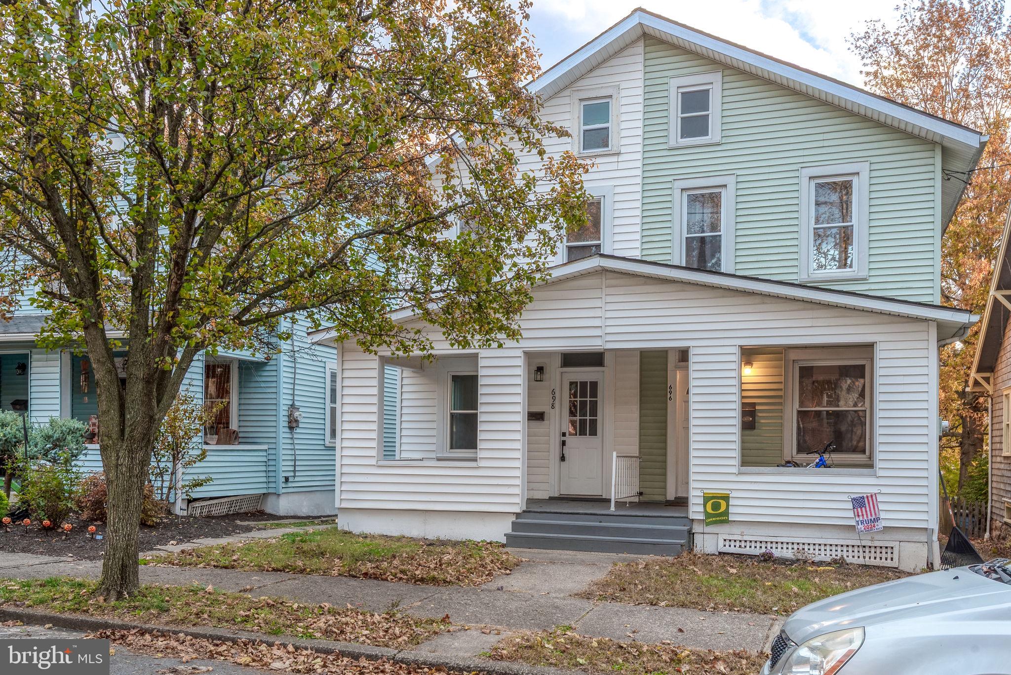 a front view of a house with a tree