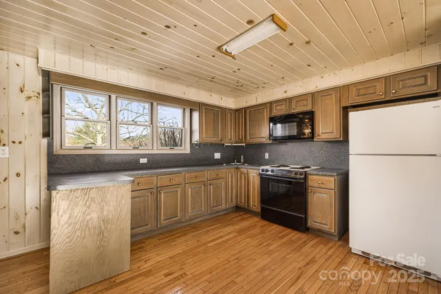 a large kitchen with stainless steel appliances granite countertop a stove and a refrigerator