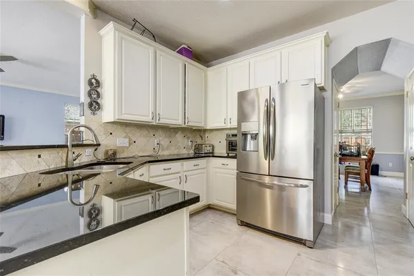 a kitchen with stainless steel appliances granite countertop a refrigerator sink and cabinets