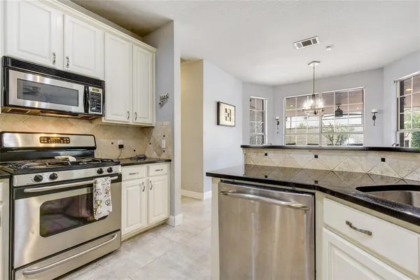 a kitchen with granite countertop cabinets stainless steel appliances and a sink