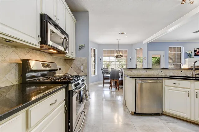 a kitchen with stainless steel appliances granite countertop a stove and a sink