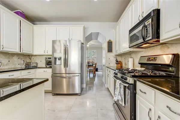 a kitchen with stainless steel appliances granite countertop a stove a refrigerator and a refrigerator