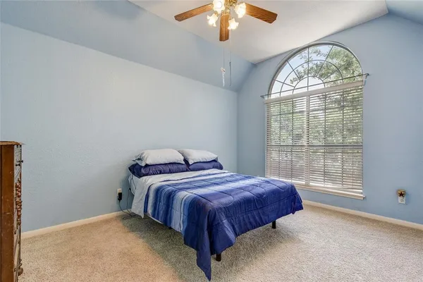 a spacious bedroom with a bed and a large window