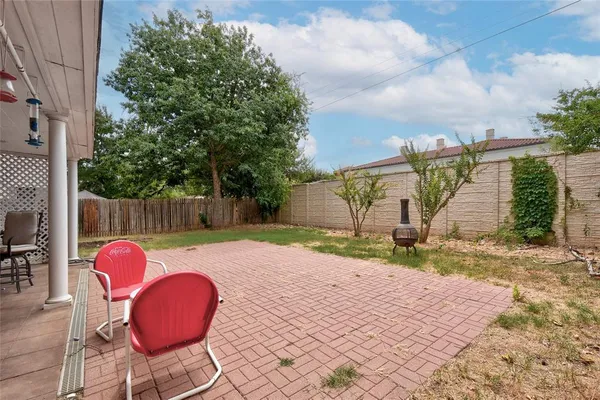 a backyard of a house with table and chairs