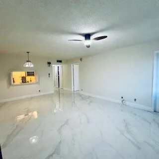 an empty room with windows and fireplace