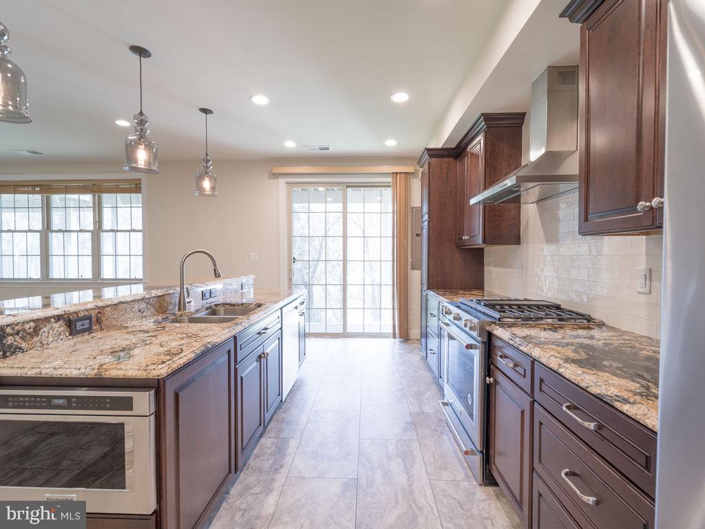 22595 Windsor Locks Square Ashburn, VA 20148 - Photo 30 of 56 a kitchen with stainless steel appliances granite countertop a stove a sink dishwasher and a refrigerator