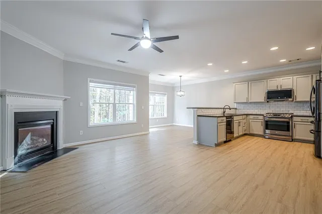 a view of kitchen with granite countertop stainless steel appliances and wooden floor