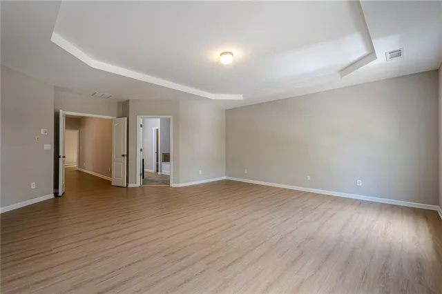 a view of an empty room with wooden floor and closet