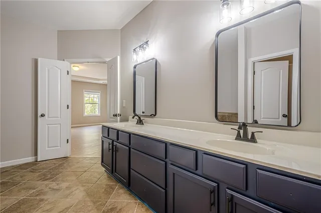 a bathroom with double vanity sinks and a mirror