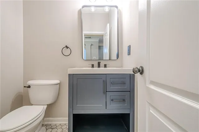 a bathroom with a sink toilet vanity and mirror