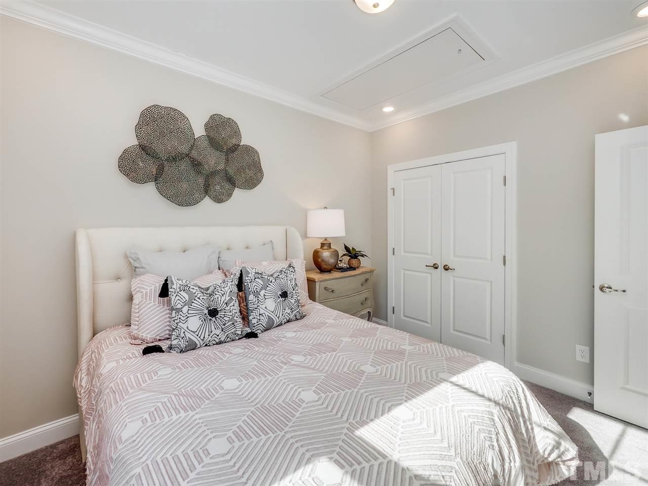 167 Azure Mist Drive, Unit 213 Raleigh, NC 27610 - Photo 14 of 24 a bedroom with a bed and a chandelier