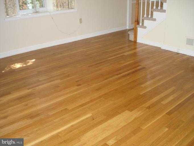 6110 Dunroming Road Baltimore, MD 21239 - Photo 3 of 11 a view of an empty room with wooden floor and a window