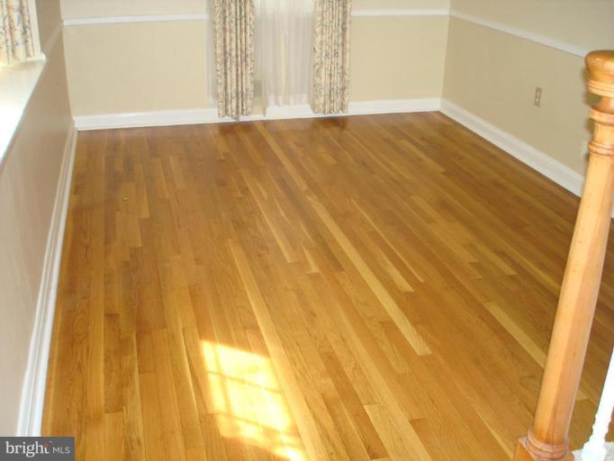 6110 Dunroming Road Baltimore, MD 21239 - Photo 4 of 11 a view of empty room with wooden floor