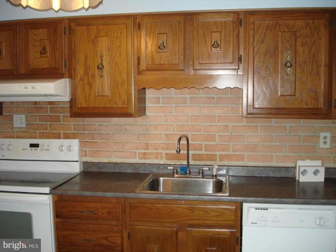 6110 Dunroming Road Baltimore, MD 21239 - Photo 6 of 11 a kitchen with stainless steel appliances granite countertop a sink and cabinets