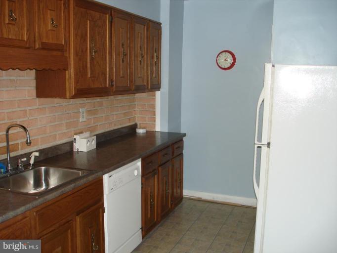 6110 Dunroming Road Baltimore, MD 21239 - Photo 7 of 11 a kitchen with granite countertop a sink stove and cabinets