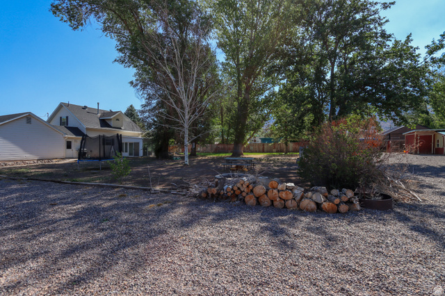 270 East 100 North Monroe, UT 84754 - Photo 47 of 65 Expansive gravel yard area with mature trees and visible woodpile