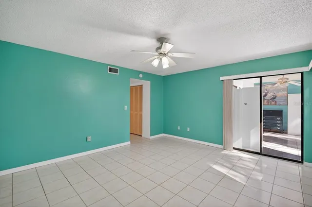 a view of an empty room with window and fan