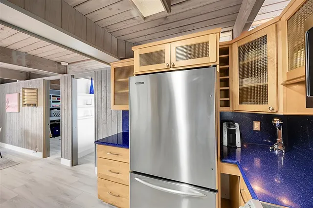 a view of kitchen with stainless steel appliances wooden floor and chair