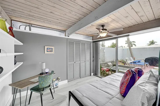 a bed room with a bed a desk and chair with the wooden floor