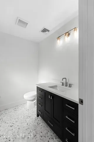 a bathroom with a toilet a sink a vanity and mirror