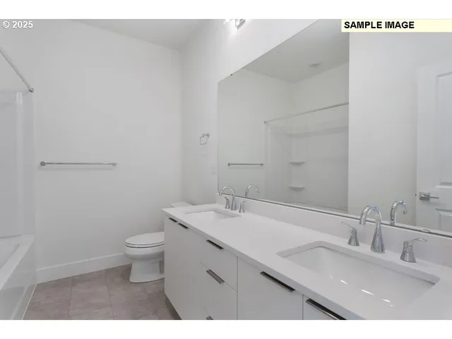 a bathroom with a granite countertop sink a toilet and a mirror