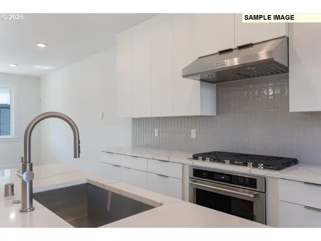 a kitchen with granite countertop a stove and a sink with wooden cabinet