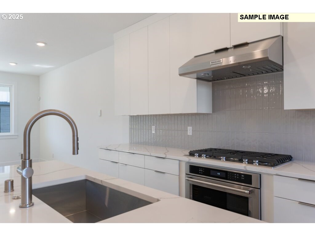 6420 Northwest Olympic Lane, Unit L47 Camas, WA 98607 - Photo 10 of 24 a kitchen with granite countertop a stove and a sink with wooden cabinet