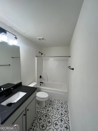 a bathroom with a sink a toilet a shower and a mirror