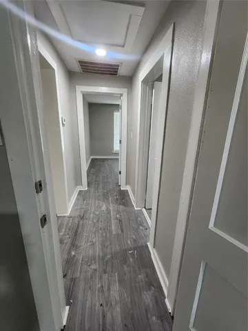 a view of a hallway with wooden floor