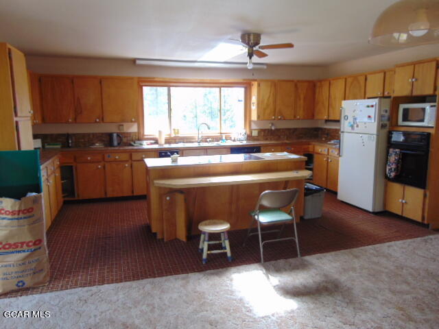 446 County Road 86 Tabernash, CO 80478 - Photo 15 of 36 a kitchen with stainless steel appliances granite countertop a stove a refrigerator a sink a dining table and chairs with wooden floor