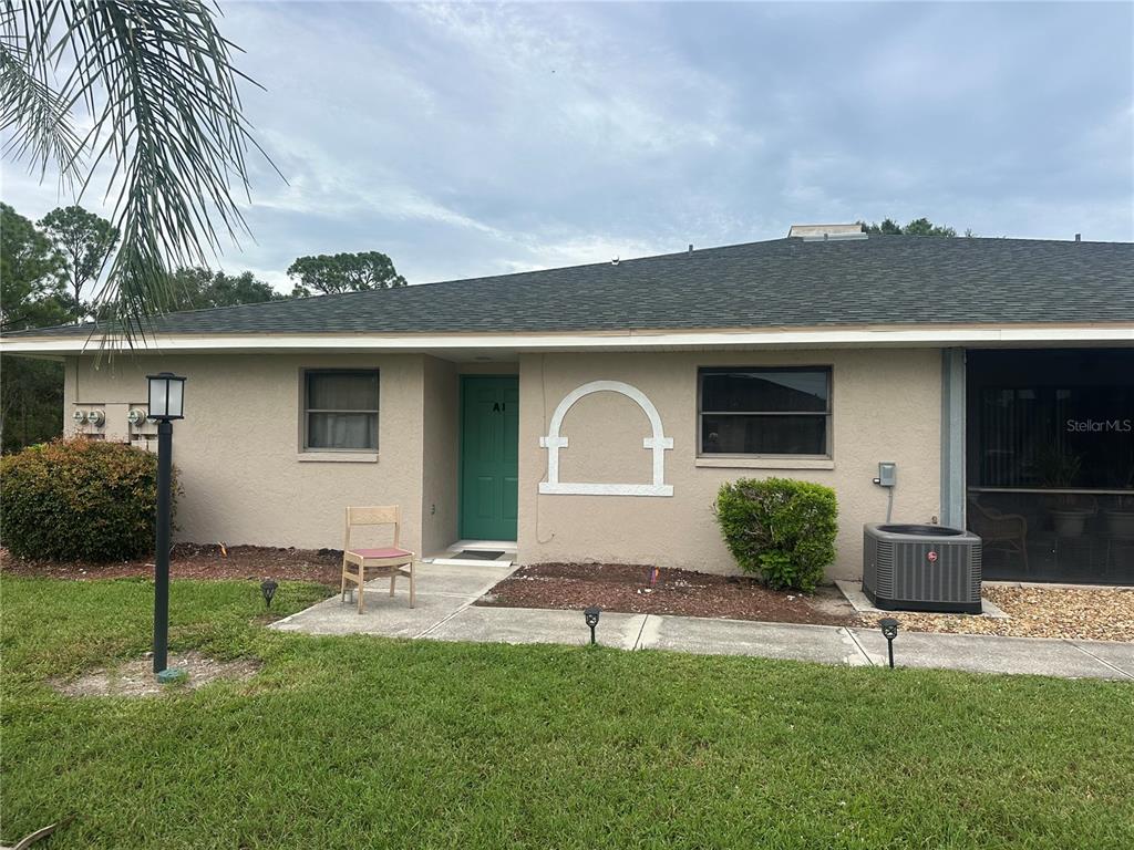 24540 Harbor View Road, Unit A1 Punta Gorda, FL 33980 - Photo 1 of 1 a front view of a house with a yard and garage