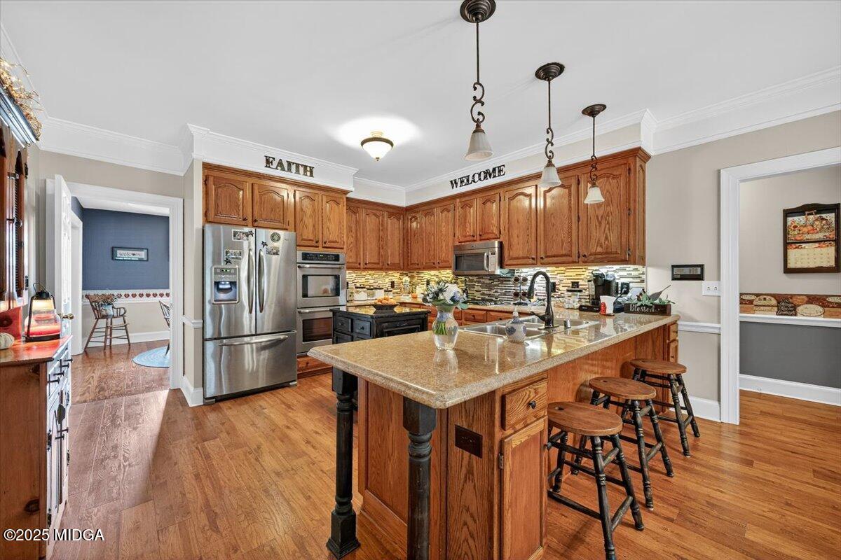 5771 Rogers Road Lizella, GA 31052 - Photo 14 of 74 a kitchen with stainless steel appliances granite countertop a refrigerator a sink dishwasher a stove and a dining table with wooden floor