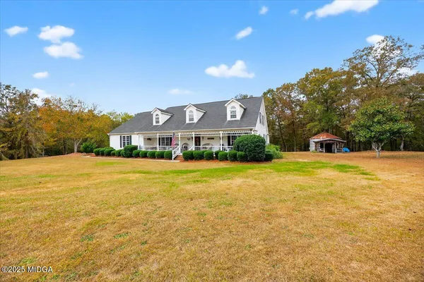 a front view of a house with a yard and swimming pool
