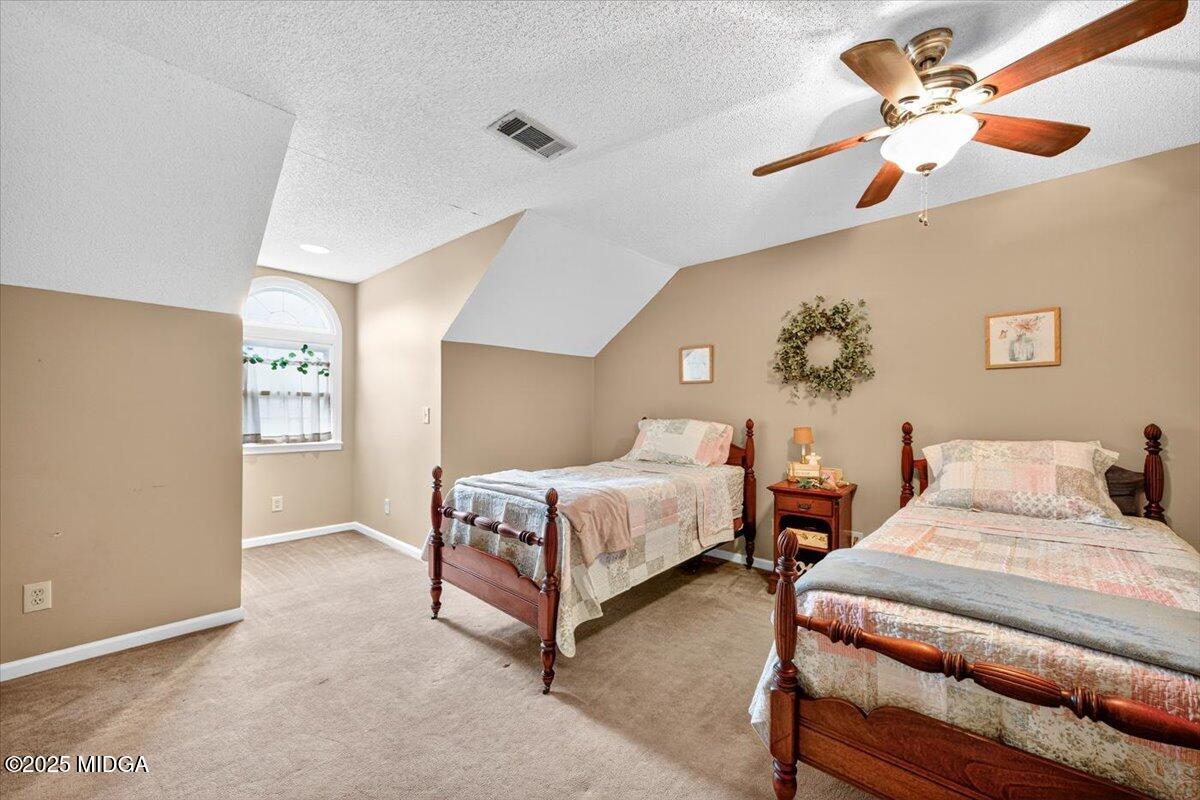 5771 Rogers Road Lizella, GA 31052 - Photo 37 of 74 a spacious bedroom with two beds and painting on the wall