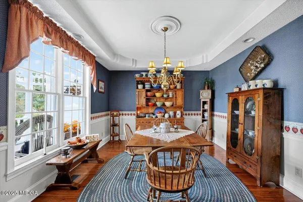 a kitchen with stainless steel appliances granite countertop a refrigerator a sink dishwasher a stove and a dining table with wooden floor