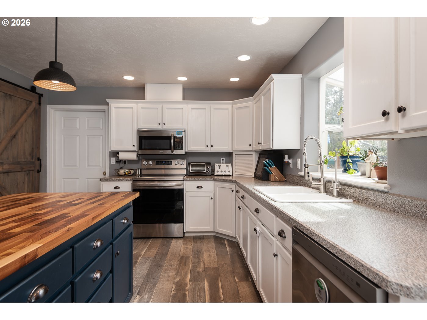 905 Southwest Burns Lane Madras, OR 97741 - Photo 21 of 40 a kitchen with kitchen island granite countertop a stove cabinets and a sink